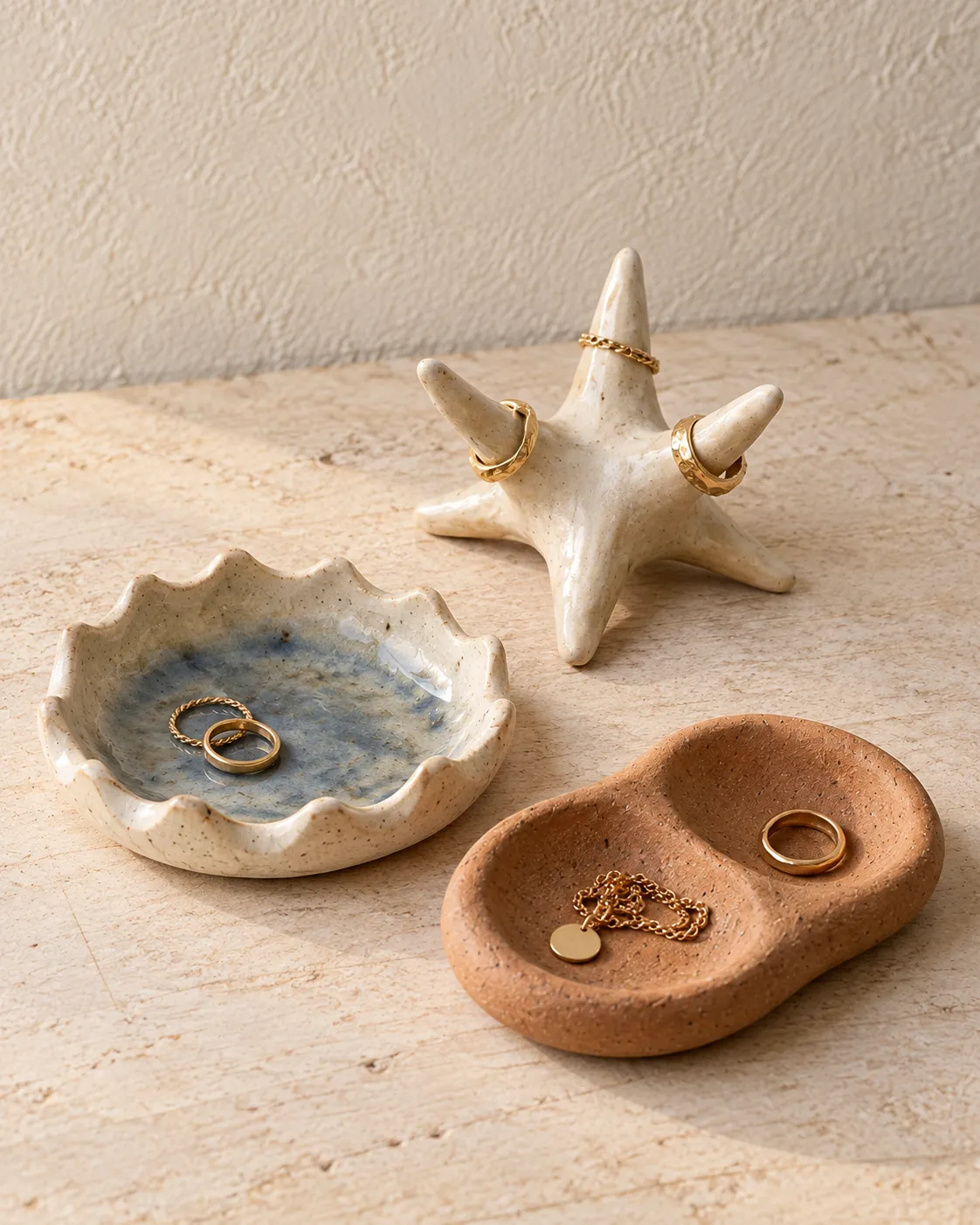 A scalloped ring dish, a starfish ring holder and a terracotta two-well tray holding jewellery